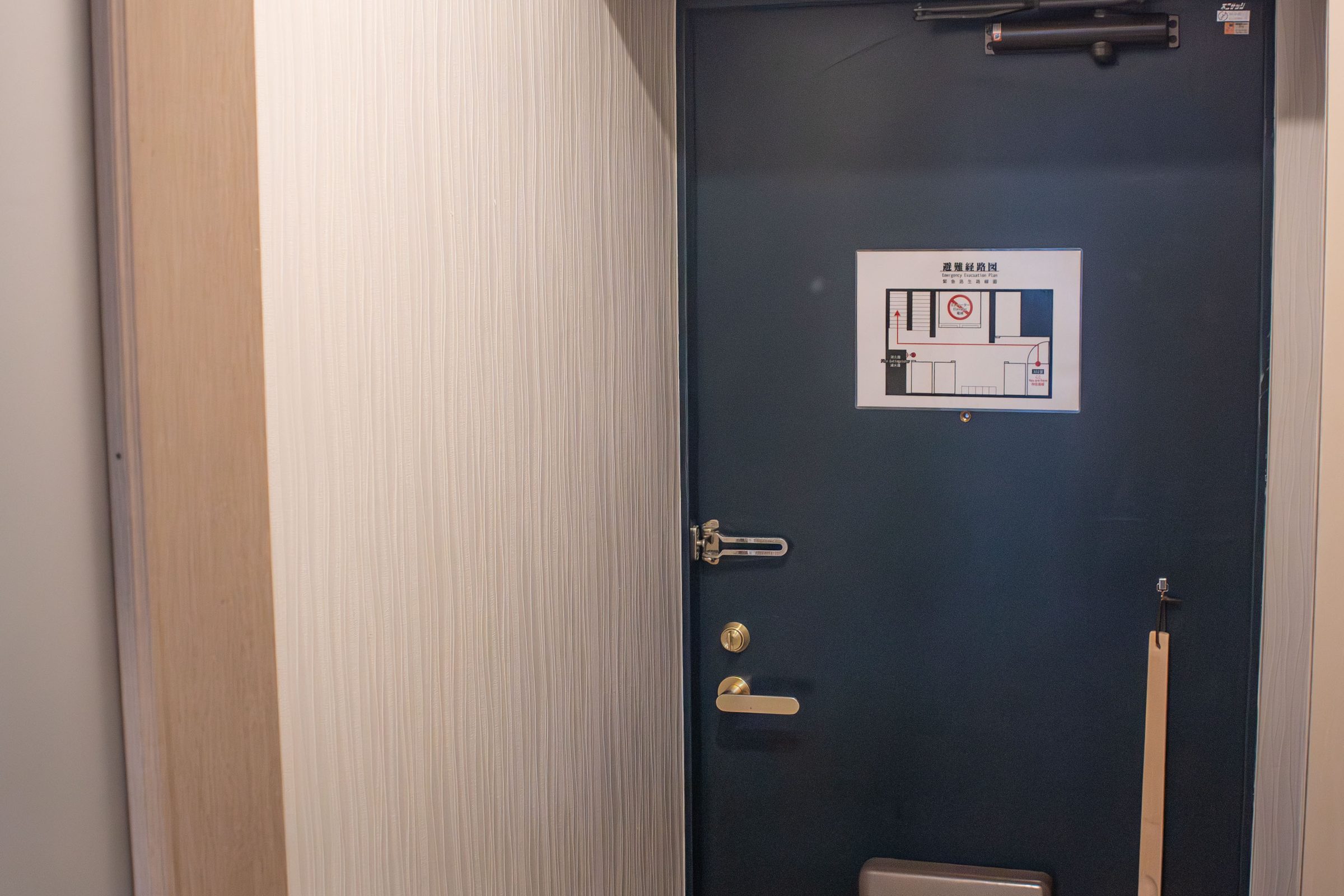 Entrance area with a dark blue door and coat hooks.